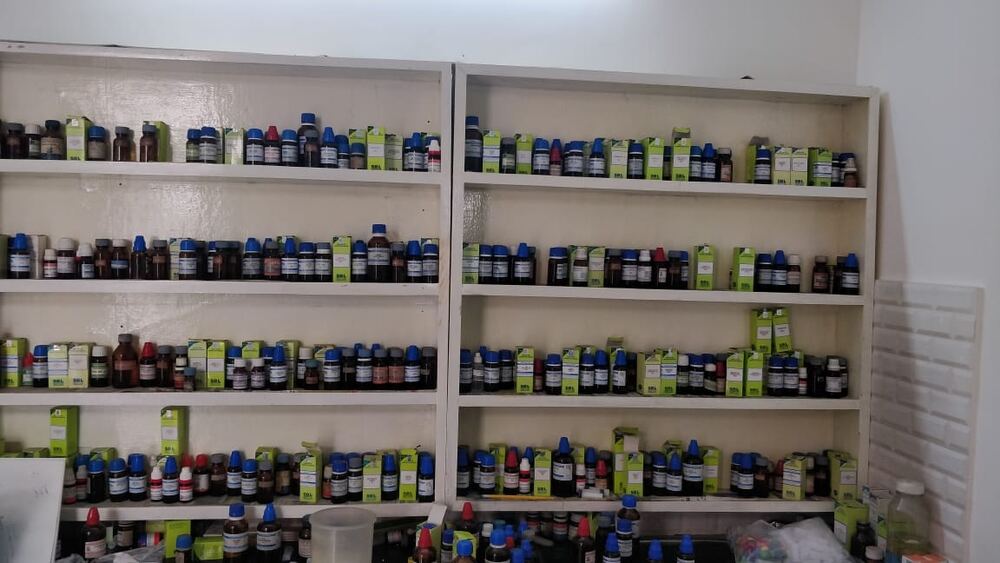 Shelves of labelled homeopathic remedy bottles at the clinic dispensary.